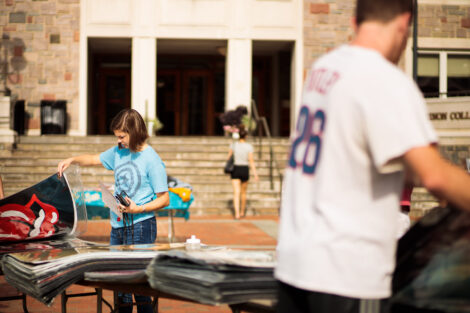 students browse posters for sale on the quad