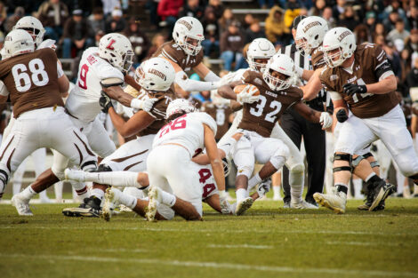 lehigh football player being absolutely stopped by lafayette defense. looks like a renaissance painting