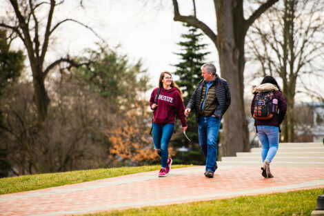 A student talks to a man while walking on campus on the first day of spring semester.