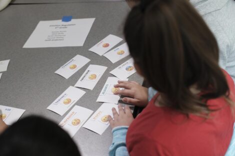 Students move emoji cards around on the table