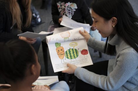 Student reads story illustrated with vegetables