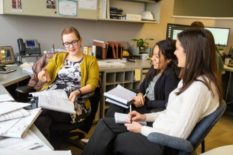 Student externs meet with host at her desk