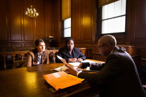 Students participating in externship sit with judge in a New York State courtroom