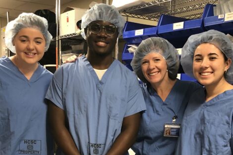 Student externs stand in blue scrubs with host