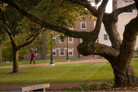 a masked student walks on campus