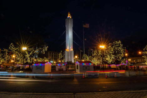 downtown Easton's Peace Candle at night with traffic going by