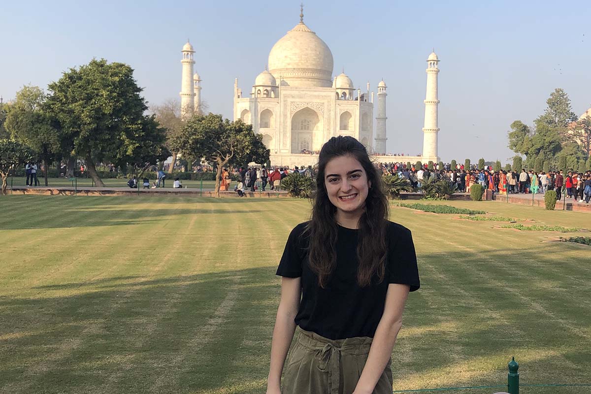 Victoria Puglia ’21, smiling, stands in front of the Taj Mahal in India.