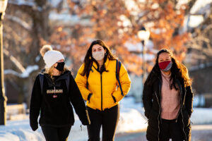 Three masked students walk