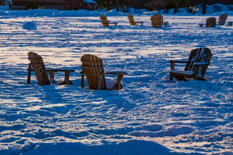 8 empty chairs are buried in snow on the Quad.