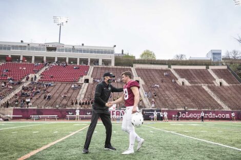 Lafayette College football coach greets player on Fisher Field