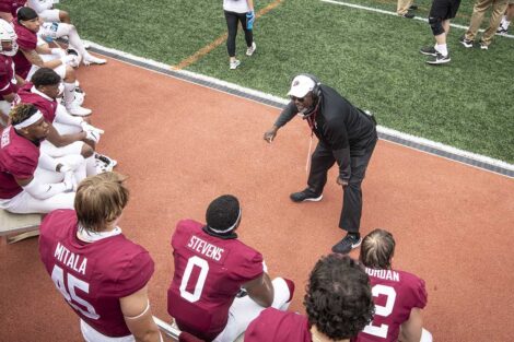 Lafayette College football coach talks to players on the sidelines