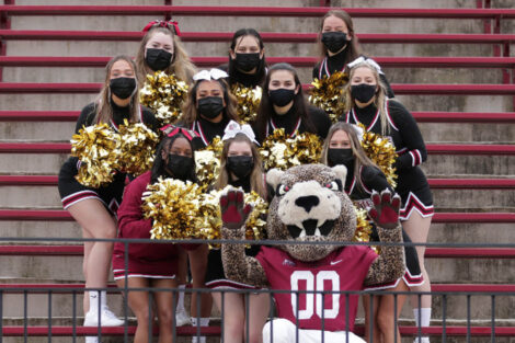 Lafayette College leopard mascot cheers on football players with cheerleaders at 156 Rivalry game
