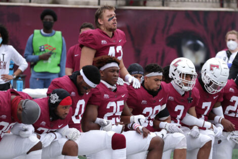 Lafayette College football players participate in a moment of silence on the sidelines