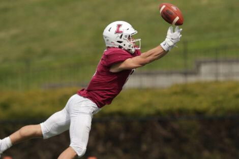 Lafayette College football player leaps and stretches to catch the football