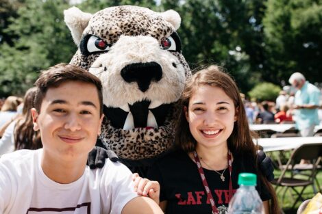 Smiling students on the Quad with the Leopard