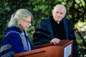 Dick McAteer listens to Leslie Muhlfelder at a ceremony awarding him an honorary degree.
