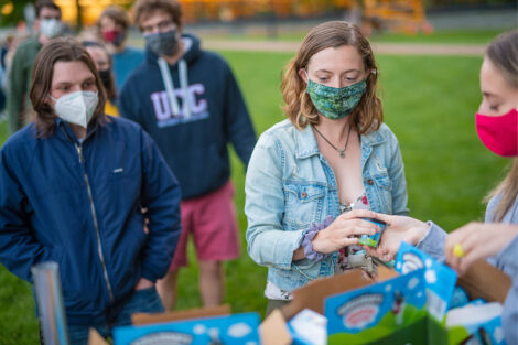 Students, wearing masks, grab a pint of ice cream.