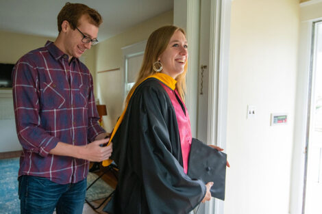 a senior gets assistance from a family member getting ready for Commencement 2021