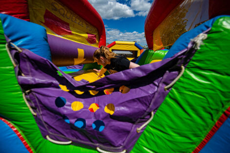 A student makes their way through an inflatable obstacle course.