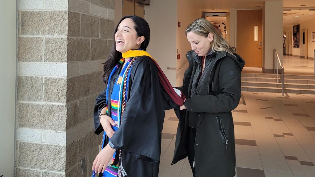 Lisa Gabel helps Karla Cariño get ready for Commencement