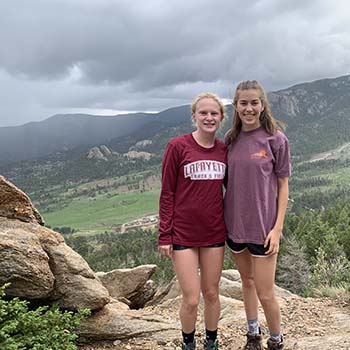 Two students in Lafayette gear stand before a range of mountains