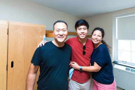 Lafayette student smiles with parents inside a dorm room
