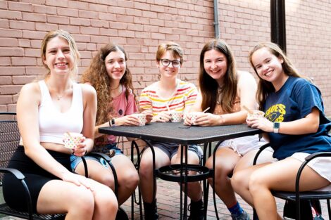Students smile, sitting at a table in downtown Easton.