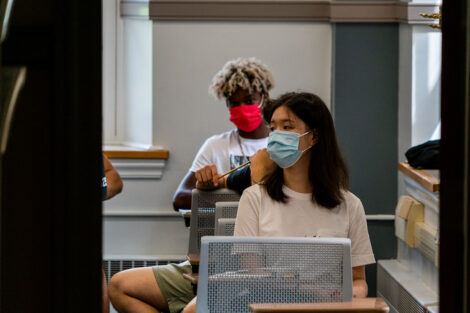Students, wearing masks, sit in desks inside of a classroom at Lafayette College.