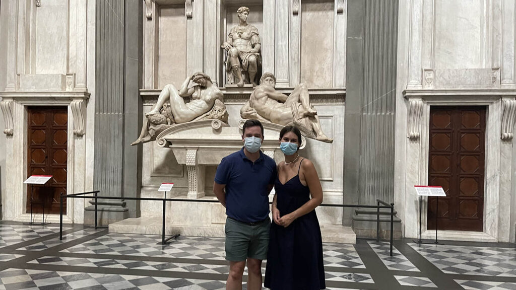 Eric Hupe and Mallory Brown stand in front of Michelangelo sculptures in Medici chapel