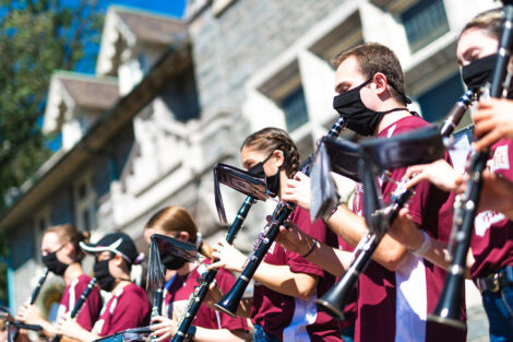 Students play clarinets in front of Hogg Hall.