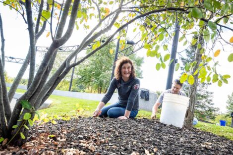 President Nicole Farmer Hurd sits in mulch of Riverside Park