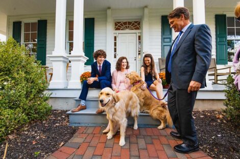 Hurd family with two golden retrievers on the steps in front of the president's residence