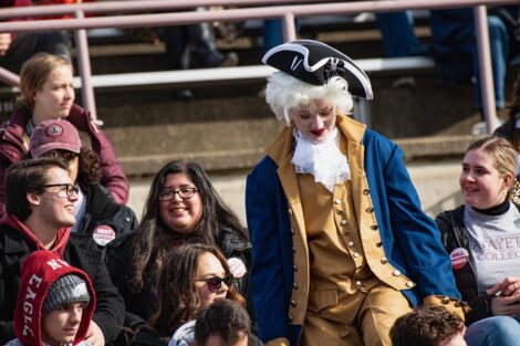 student dressed as Marquis de Lafayette surrounded by other Leopard fans in the stands