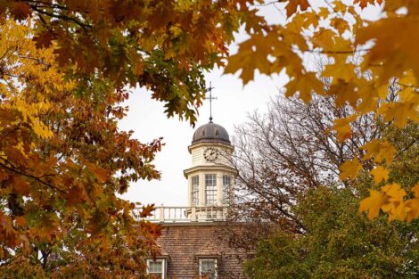 The top of Kirby Residence Hall peeks through the fall foliage