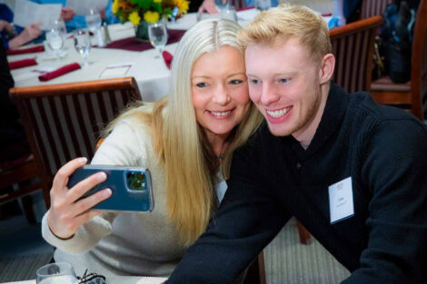 Mira van Roon Brand '92 with son, Carter Brand '25. They are taking a photo of themselves with Mira's camera.
