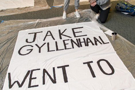 Students stand in front of a banner that reads 