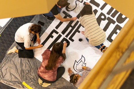Students paint a banner that will read 