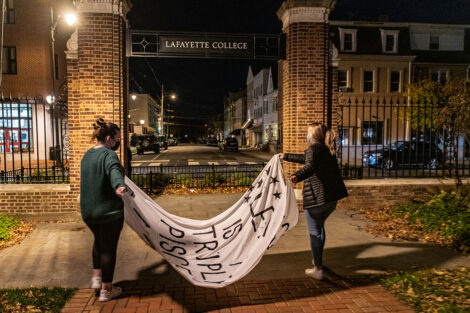 Students carry a banner across campus.