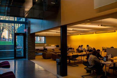 the sun sets outside the ground floor of Skillman library, where students stuy