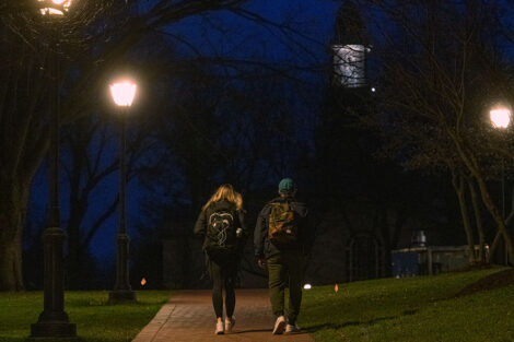 students walk away from the camera, toward Colton Chapel at nighttime