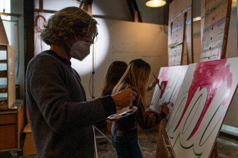 art students paint signs on easels