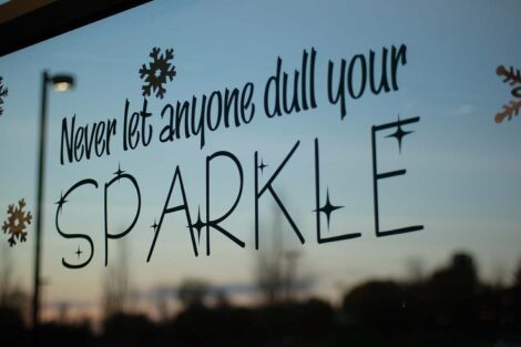 Decal on window says Don't let anyone dull your sparkle. Sun sets in background