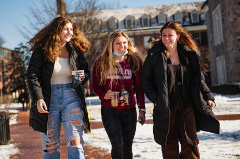 Three students, walk across Lafayette College's campus.