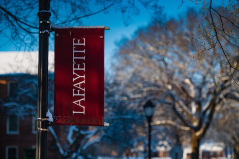 Lafayette College flag hangs from a lamp post.