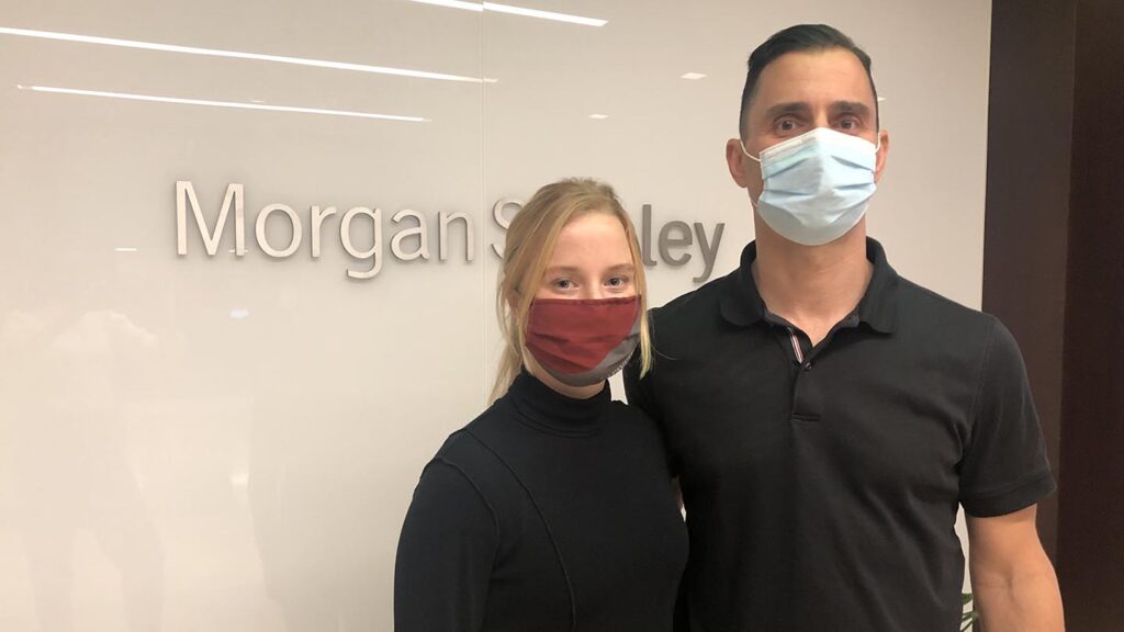 Host and student stand in front of Morgan Stanley sign