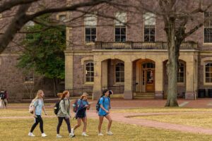 students walk across the Quad in spring attire
