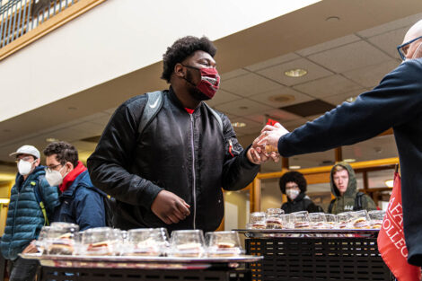 student in mask is given a cupcake in Farinon
