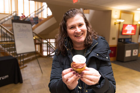 Nicole Farmer Hurd holds a cupcake and smiles