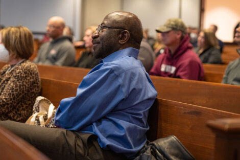 Rex Ahene sits with other faculty and staff in Colton Chapel