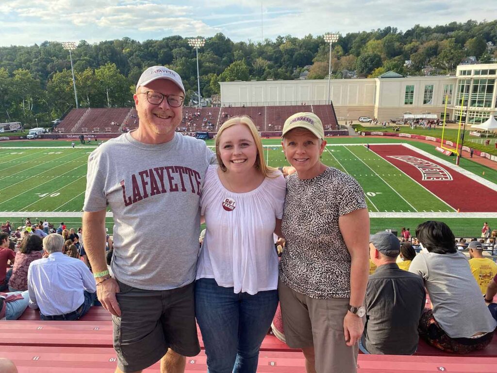 Bryn Cranswick ’23 and her parents, Russ Cranswick P’23 and Sheila Black P’23 are outside at Kirby Stadium. 